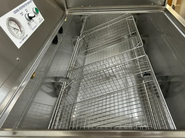 Stainless steel respirator washer with baskets.